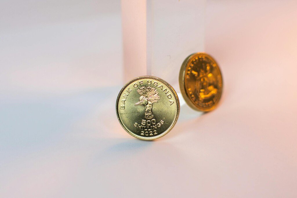 Artistic shot of Ugandan coins featuring creative lighting and macro details, showcasing currency and financial concepts.
