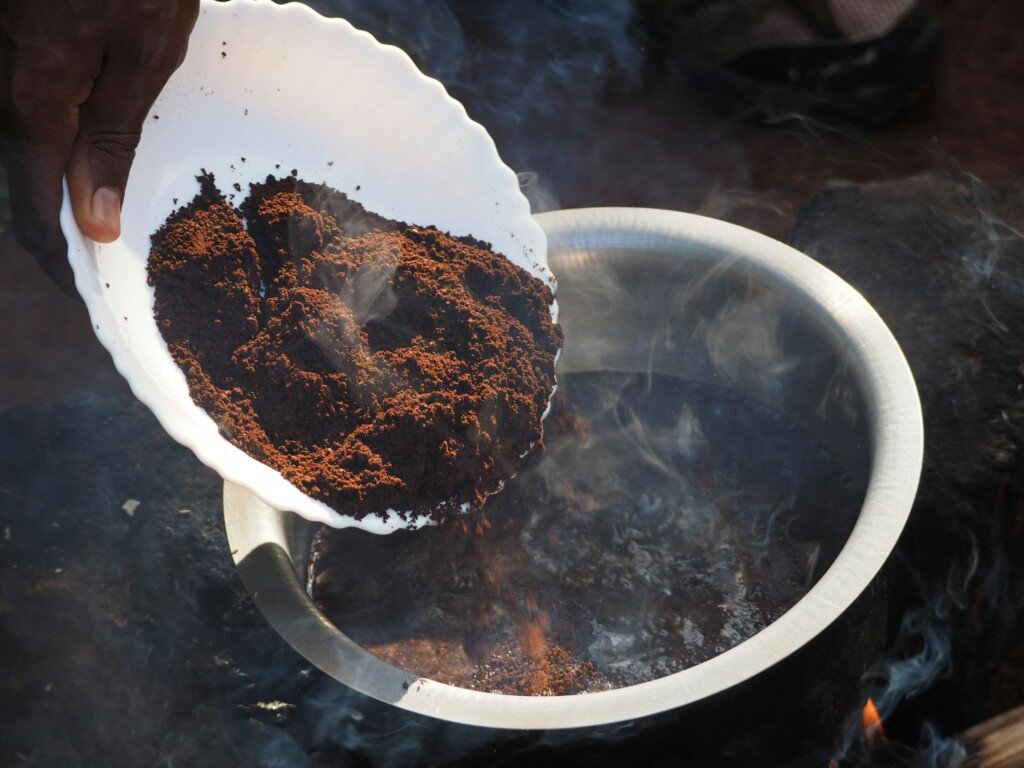 Close-up of coffee brewing in Sipi, Uganda, showcasing traditional methods over an open flame.