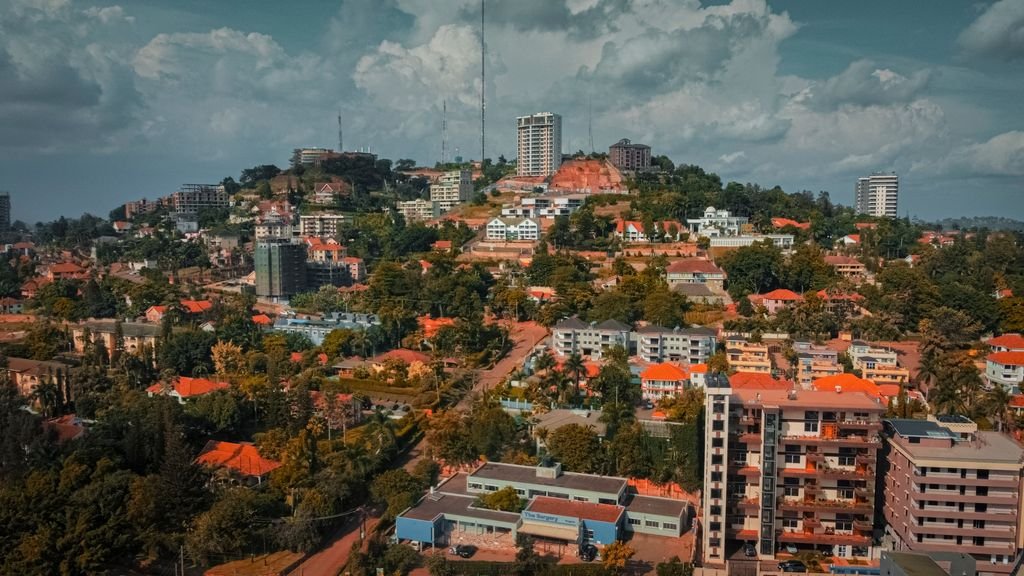 A picturesque view of a vibrant hilltop residential district under a summer sky.